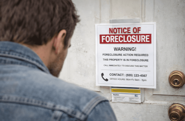 notice of foreclosure posted on front door man reading notice of foreclosure that was posted on his door