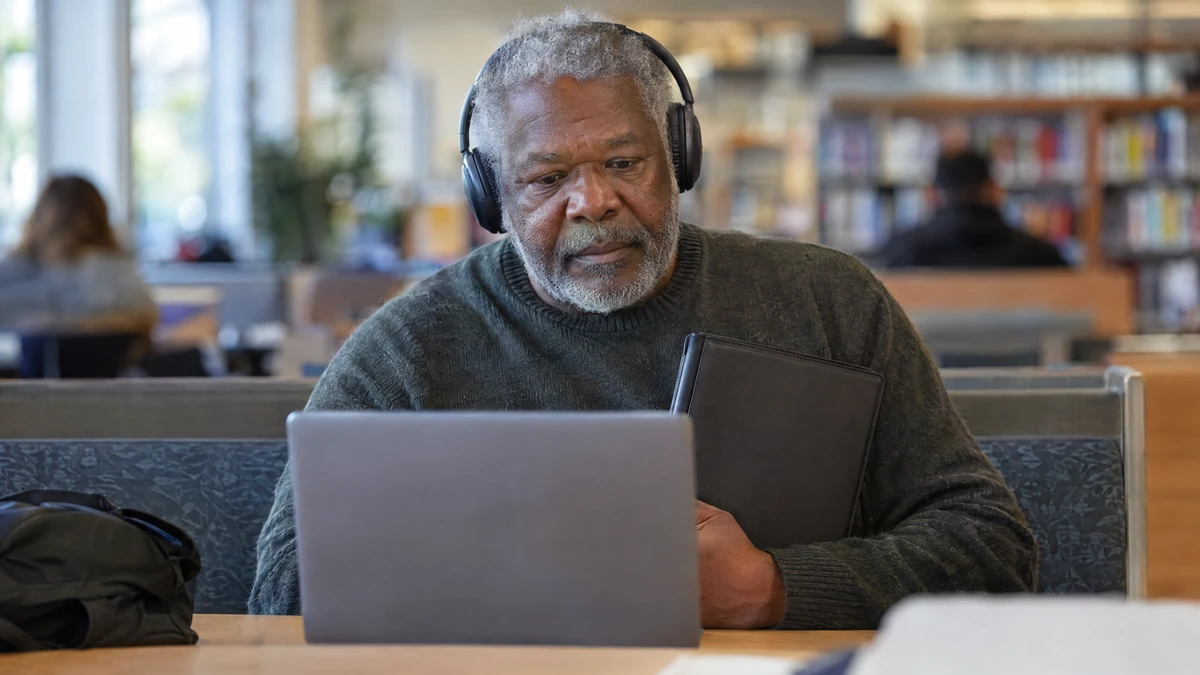 A man checks credit counseling costs at a library before preparing his household budget.